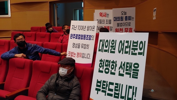 일부 참석자들이 이날 표결에 대해 피켓으로 항의하고 있다.