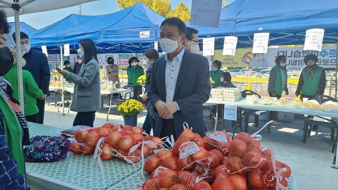 완주군의회 김재천 의장이 농산물 상생마켓을 찾아 농민과 대화를 나누고 있다.