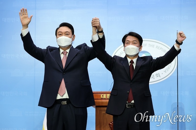 윤석열 국민의힘 대선 후보와 안철수 국민의당 대선 후보가 3일 오전 서울 여의도 국회 소통관에서 단일화 기자회견을 마치고 손을 맞잡고 있다./ⓒ 공동취재사진