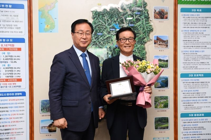 김영기 회장(오른쪽)이 29일 완주군 ‘1일 군수’로 위촉된 뒤, 유희태 완주군수와 기념사진을 찍으며 환하게 웃고 있다. /완주군