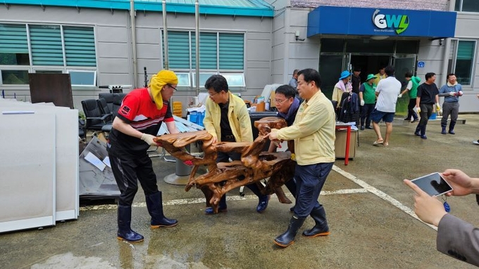 17일 오전 안호영 국회의원과 군의원들은 잠시 소강상태를 보인 상황에서 고산면 남봉리의 침수피해를 입은 사무실을 찾아 사무집기를 나르고, 건물안에 토사를 치우는 등 구슬땀을 흘렸다. /유범수 기자