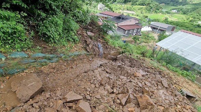 동상면 밤티마을 한 주택 뒤 산에서 토사가 쓸려 내려오고 있다.