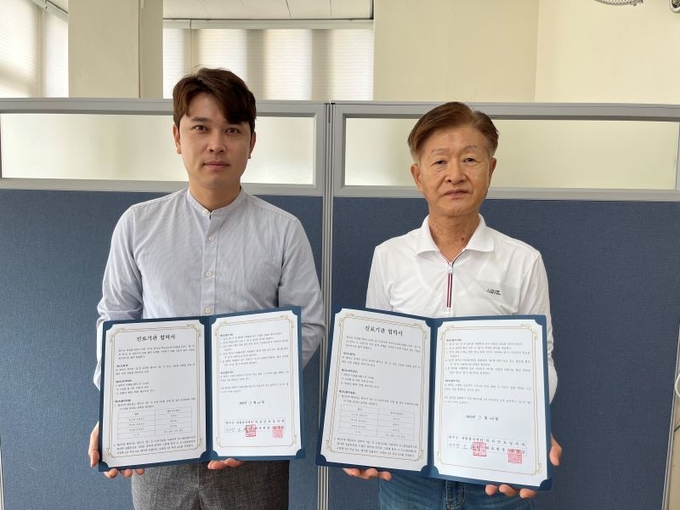최영만 완주군자원봉사센터장(오른쪽)이 신경섭 혁신굿모닝치과원장(왼쪽)과 자원봉사자 인센티브를 위한 업무협약을 체결했다. /완주군