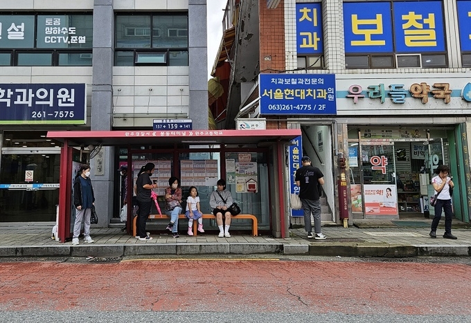 봉동읍내 한 정류장에서 오지 않는 버스를 하염없이 기다리는 주민들
