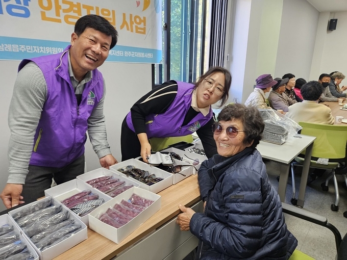 윤현철 위원장(왼쪽)과 어르신이 활짝 웃고 있다.