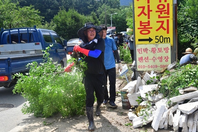 부러진 나무가지를 옮기는 유의식 의장