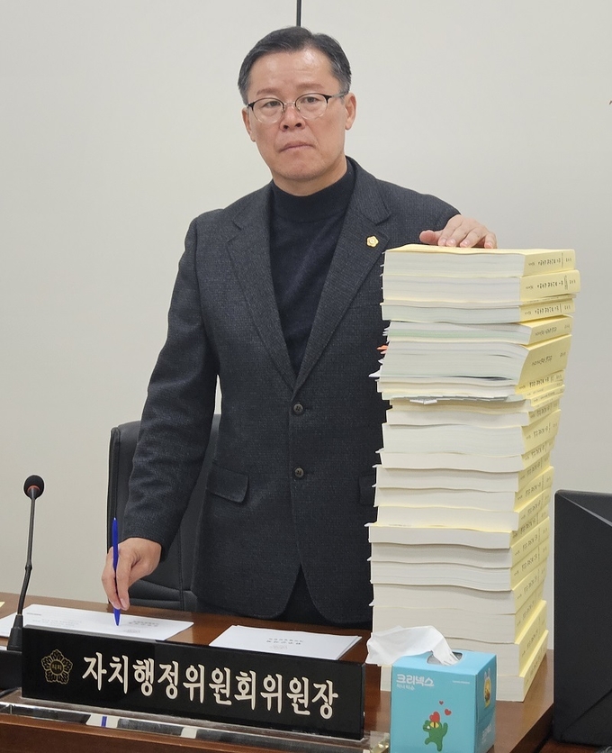 회의 전 이주갑 자치행정위원장이 늦게 도착한 예산관련 자료를 쌓아놓고 분개 중이다.