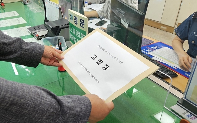 완주전주통합반대대책위원회 관계자가 11일 완주경찰서에 고발장을 접수 중이다.
