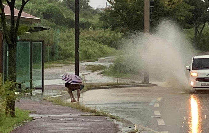 이주갑 완주군의원이 사고 방지를 위해 고인물 맨홀을 정리 중이다.